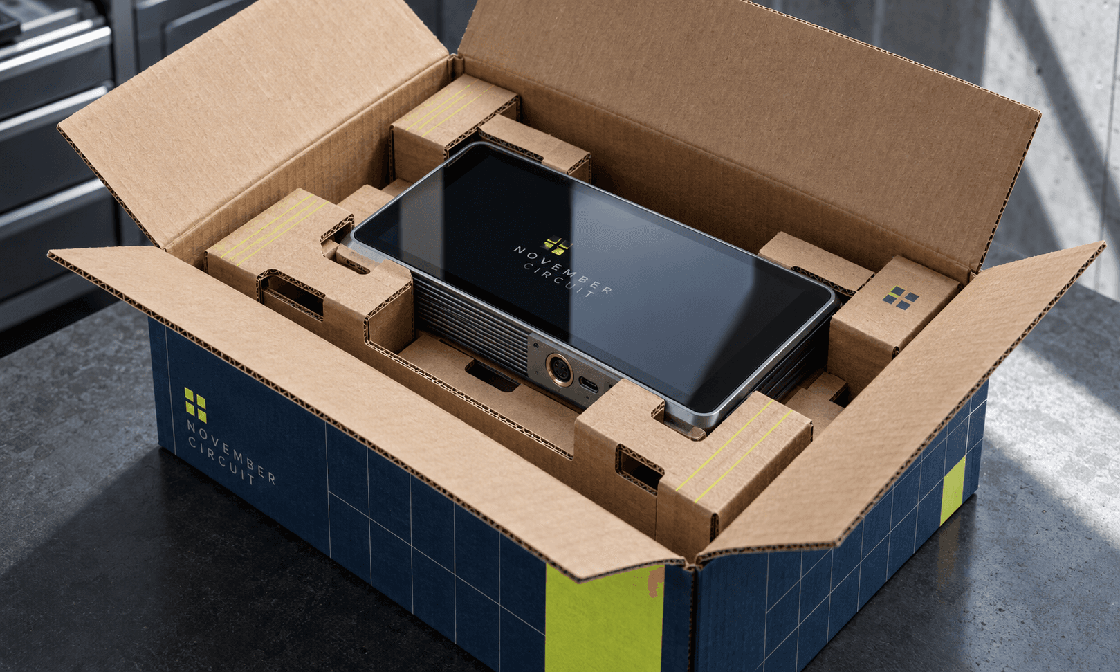 Double-wall corrugated box with a fitted cradle protecting a fragile electronic device with screen and connectors.